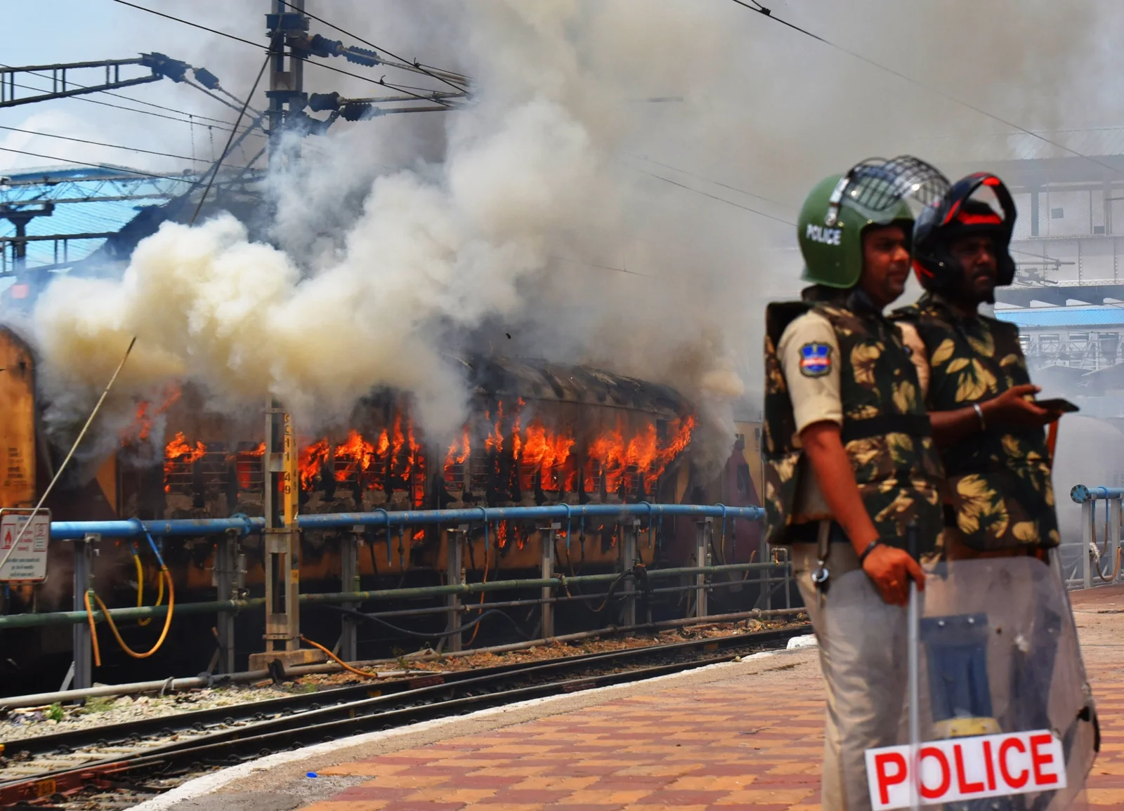 Police officers stand in front of flames and smoke in a photograph from the portfolio.