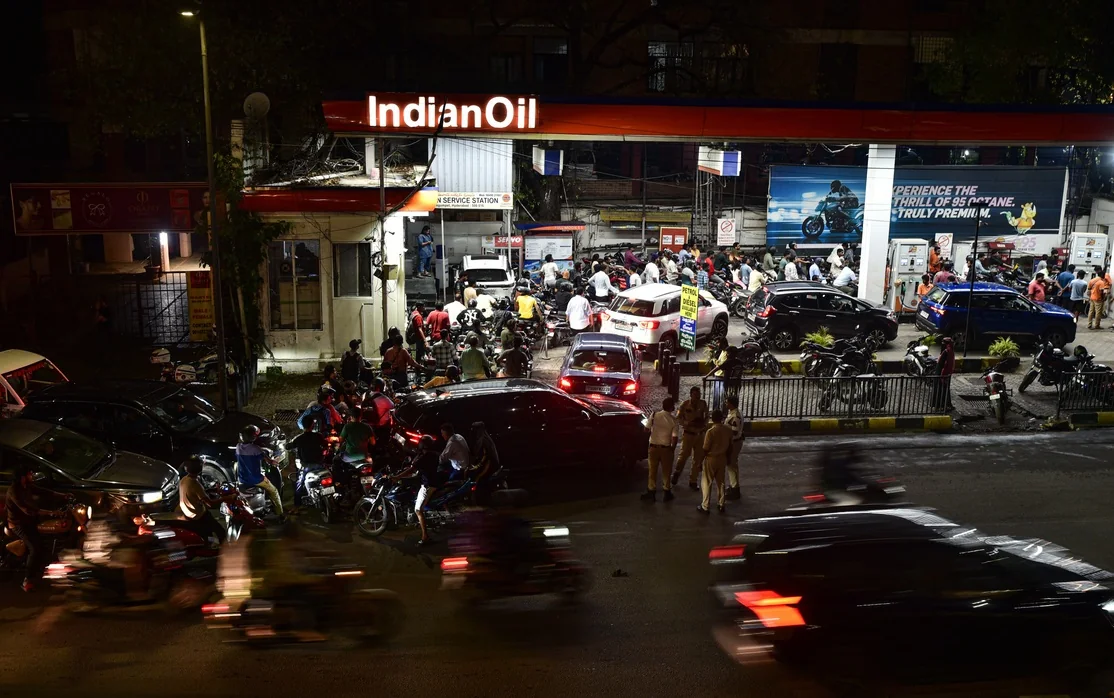 Vehicles crowd a Hyderabad fuel station after dark.