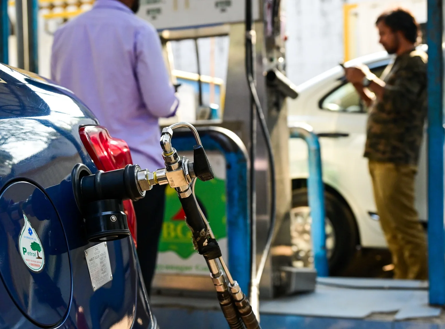 A fuel-station worker fills a vehicle with compressed natural gas in Hyderabad.